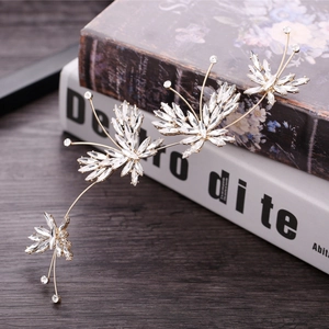 Barrette de mariée papillon dorée avec cristaux marquise sur des livres anciens