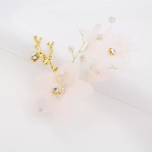 Détail de barrettes fleurs en tulle rose avec branches dorées et cristaux étincelants