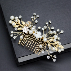 Close-up of handmade bridal hair comb with pearls, crystals and floral alloy details