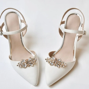 Detailansicht der Strass-Schuhclips an eleganten cremefarbenen Satin-Brautschuhen