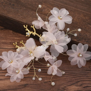Détails de fleurs en tulle rose et perles blanches sur cet accessoire de coiffure mariée