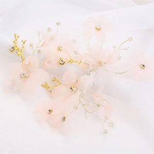 Détail de barrettes de mariée avec fleurs en gaze, perles de cristal et fil doré