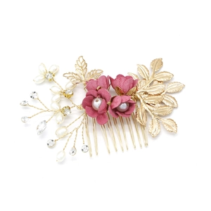 Detail von rosa Stoffblumen und weißen Perlen auf einem goldenen Hochzeits-Haarkamm