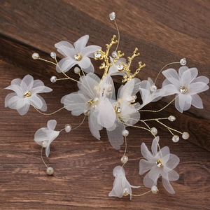 Détail de pinces à cheveux de mariée avec fleurs en organza et perles blanches