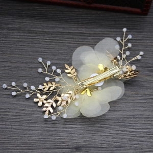 Dettaglio del fermaglio per capelli con fiore in tulle fatto a mano e foglie dorate