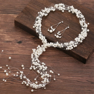 Détail macro d'une vigne de perles de mariée et boucles d'oreilles sur fond en bois ancien