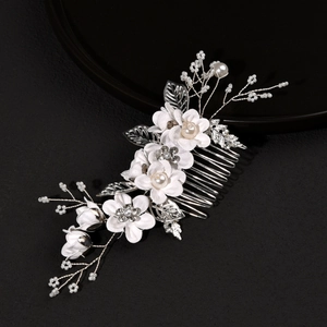 Détail d'un peigne de mariée avec fleurs en tissu blanc, perles et strass