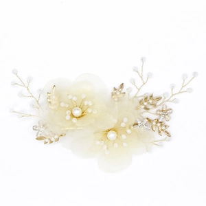 Dettaglio fermaglio da sposa con fiori in rete color crema e perle decorative centrali