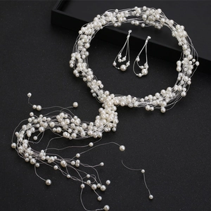 Détail d'une parure de mariage avec collier de perles tressé et boucles d'oreilles assorties