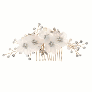 Détail d'un peigne à cheveux de mariée avec fleurs en tissu ivoire et strass brillants