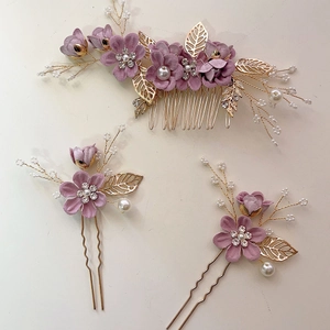 Detail view of purple floral hair comb and U-shaped pins with gold leaves and pearls