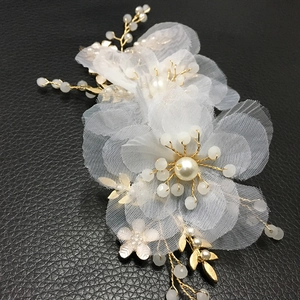 Dettaglio macro dell'accessorio sposa con fiori di maglia e perle finte eleganti