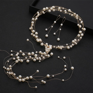 Vue macro d'un bijou de tête en perles blanches fait main et boucles d'oreilles pour mariée