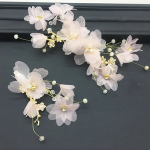Détail de pinces à cheveux fleurs en tulle rose faites main avec fil d'or et perles