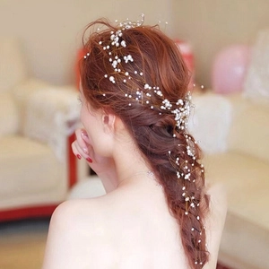 Détail d'un accessoire de mariage avec perles et fil doré tressés dans une coiffure élégante