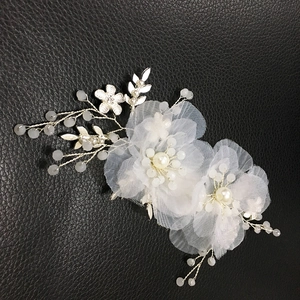 Dettaglio accessorio capelli sposa con fiori di seta beige, perle e foglie argento