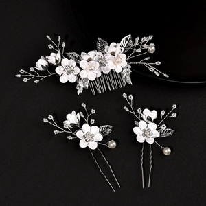 Close-up of bridal hair accessory set with white fabric flowers, pearls and rhinestones