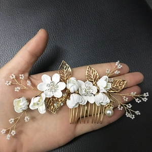 Vue détaillée d'un peigne à cheveux de mariée avec fleurs blanches et feuilles dorées