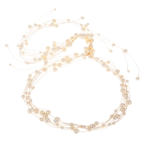 Détail d'un bandeau de mariée fait main avec fil doré et perles blanches élégantes