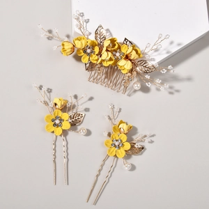 Close-up of three-piece yellow floral hair comb and pin set with pearls and gold leaves