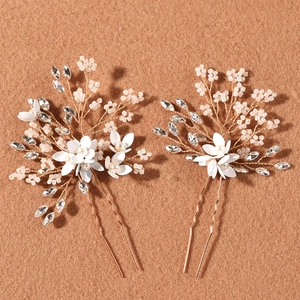 Detail view of handmade bridal hair pins with white enamel flowers and pearls