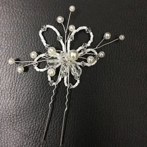 Détail d'une épingle à cheveux de mariée avec perles blanches, cristaux et fil d'argent