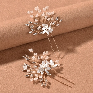 Detail of handmade bridal hair pins with white resin flowers and faux pearls on gold wire
