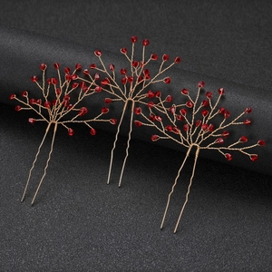 Detailed macro view of three red crystal beads and gold wire handmade bridal hair pins