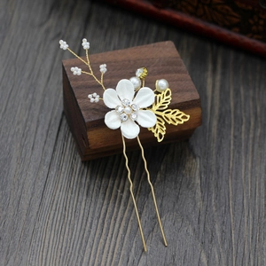 Detailed close-up of handmade bridal hair pin with silk white flower and pearls