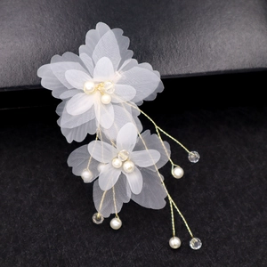 Gros plan détaillé de fleurs en organza faites main avec perles et fils dorés élégants