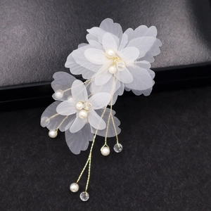 Détail de la pince à cheveux fleur de mariée blanche avec perles et cristal sur cuir