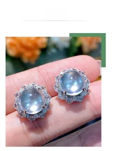 Gros plan de boucles d'oreilles en argent avec pierre de lune bleue et halo de cristaux