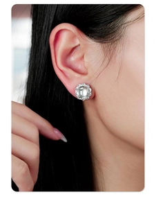 Gros plan détaillé de boucles d'oreilles en quartz blanc avec un halo de diamants