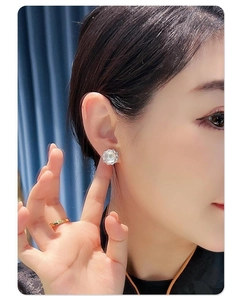 Vue détaillée de boucles d'oreilles tournesol avec perle blanche et halo de zircon