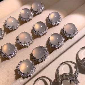 Anello elegante in calcedonio bianco con pietra ovale e bordo di zirconi brillanti