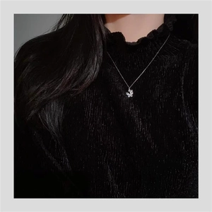 Dettaglio di una elegante collana con ciondolo a farfalla in argento sterling su modella