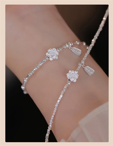 Macro detail of S925 silver bamboo chain with lotus charm and Hope engraved tag