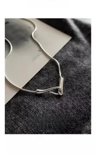 Close-up of minimalist S925 sterling silver snake chain with unique S-hook clasp detail