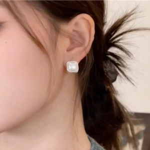 Minimalist square pearl stud earrings with sparkling pavé diamonds worn by model