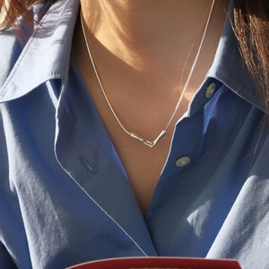 Minimalist silver geometric V-pendant necklace on a delicate snake chain for women