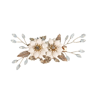 Elegant bridal hair clip featuring handmade white flowers, gold leaves, and crystal beads