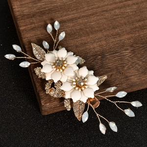 Elegant bridal hair clip with white enamel flowers and gold rhinestone leaf accents