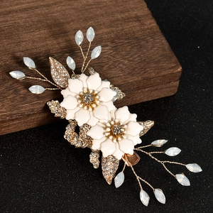 Elegant bridal flower hair clip with white petals and gold leaves for wedding styling
