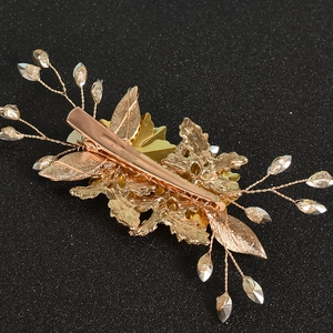 Detailed view of golden leaf hair clip with crystal beads and metal duckbill clip back