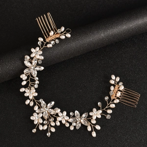 Close-up of handmade pearl and crystal flower bridal hair comb with gold wire details