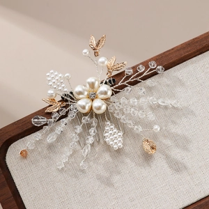 Peigne à cheveux de mariée avec perles, cristaux et feuilles d'or sur texture lin
