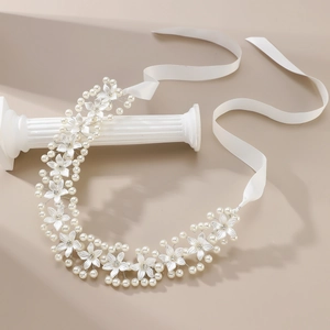 Bandeau de mariée élégant avec perles, fleurs et strass sur un fond beige chaleureux