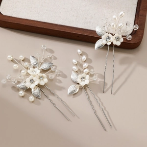 Three-piece bridal hair pin set with white ceramic flowers, pearls and silver leaves