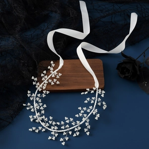 Elegant bridal hairband with white pearls and silver wire on blue background with ribbons