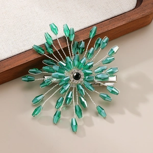 Macro detail of handmade bridal hair clip with green beads and silver metal base